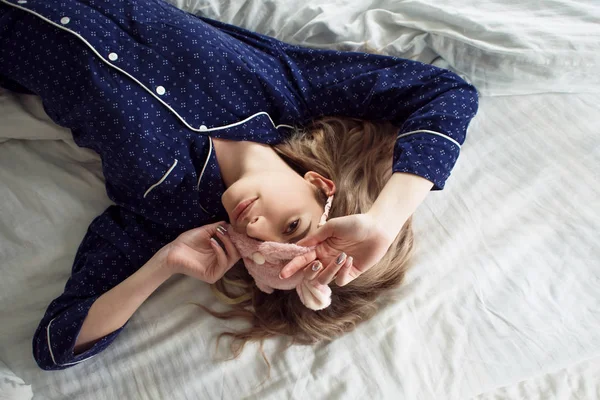 Loira bonito em sua cama em pijama azul e máscara de sono, vista superior — Fotografia de Stock