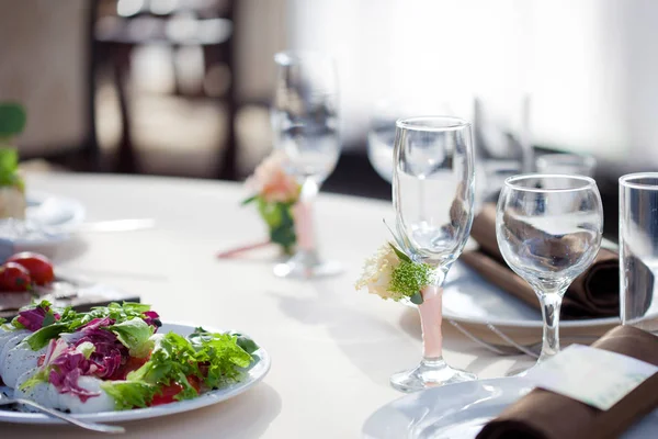 Nakrycie stołu w restauracji. kwiatowe dekoracje na okulary, ślub — Zdjęcie stockowe