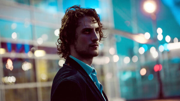 Молодой стильный парень на фоне ночного города, городских огней
