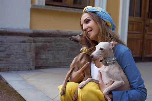 Şık ve güzel bir genç kadın köpeklerle yürür