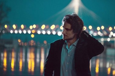 Gece şehir, şehir ışıkları arka plan üzerinde şık genç adam