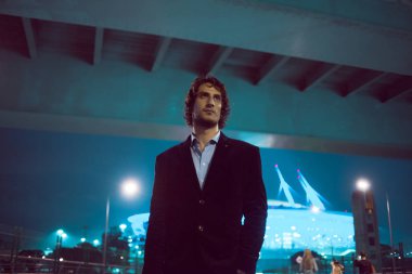 Gece şehir, şehir ışıkları arka plan üzerinde şık genç adam