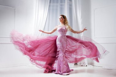 Bir tren şık pembe elbiseli çekici bayan. Beyaz iç stüdyo portre