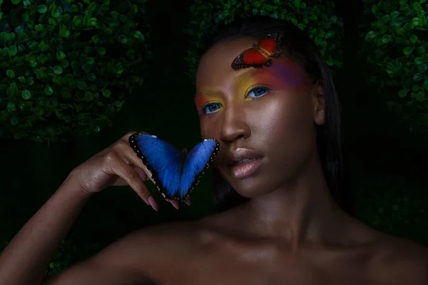 Mladý a krásný černý model exotický vzhled s jasně modrým motýlem — Stock fotografie