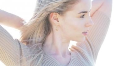 Deniz kıyısı genç neşeli kız. Sarışın genç kadın gülümsüyor. Kollarını açarak hugs okyanus