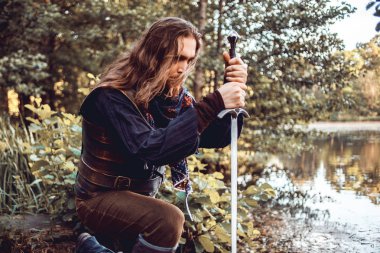 Knight bir kılıç ile diz eğdi