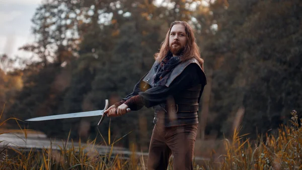 Cavaleiro na floresta. Um tipo de fato medieval com uma espada — Fotografia de Stock