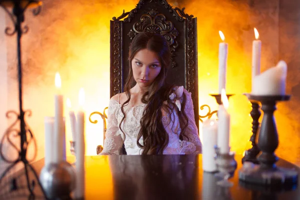 Красивая молодая женщина в винтажном платье, за столом в мистическом поместье — стоковое фото