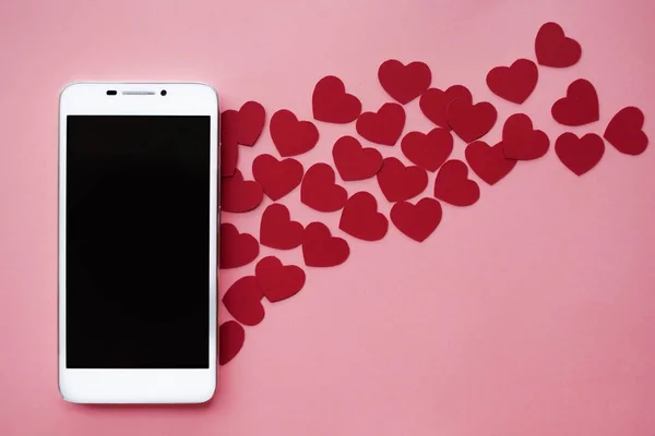 Vele harten en smartphone. Concept graag in sociale netwerken of Dating app. roze achtergrond — Stockfoto