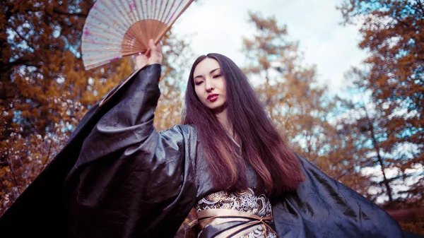 Танцующая молодая женщина в кимоно, азиатский костюм — стоковое фото