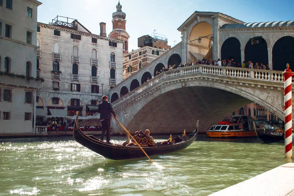 VENECIA, ITALIA - 7 DE OCTUBRE DE 2017: Gondolier flota en el Gran Canal, el puente de Rialto en el fondo —  Fotos de Stock