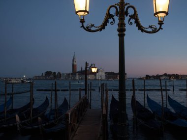 Saint Mark arka plan üzerinde San Giorgio di Maggiore Kilisesi ile kare tarafından demirlemiş gondol