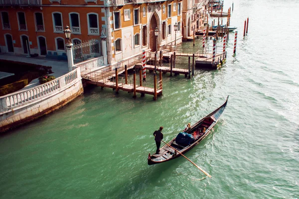 Gondolier floats on the Grand Canal, the Rialto bridge in the background