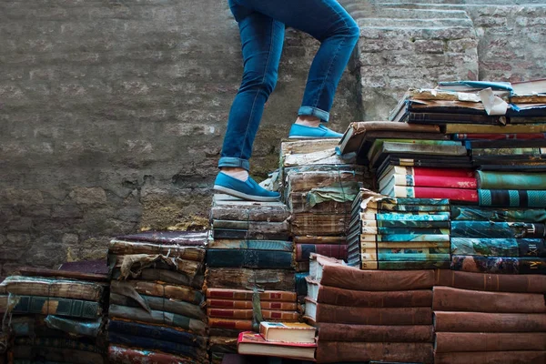Edukacja, koncepcja. Młoda kobieta wspina się po schodach książek — Zdjęcie stockowe