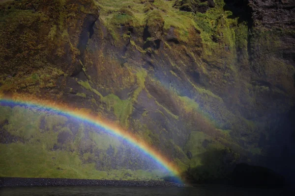 Gökkuşağı arka plan üzerinde kayalar, ayak Skogafoss şelale, İzlanda — Stok fotoğraf