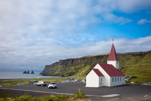 Island, die Kirche vor der Kulisse schöner Felsen. Vik — Stockfoto