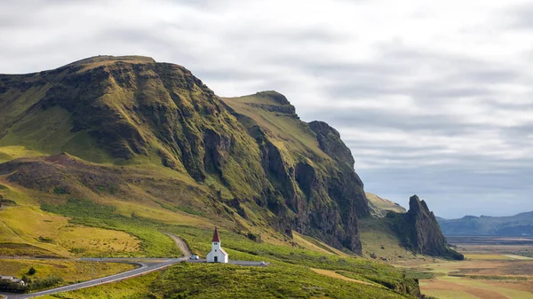 Island, die Kirche vor der Kulisse schöner Felsen. Vik — Stockfoto