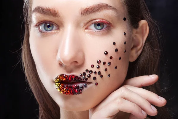 Menina bonita nova com olhos azuis. Maquiagem brilhante, batom vermelho. Arte, strass nos lábios e no rosto — Fotografia de Stock