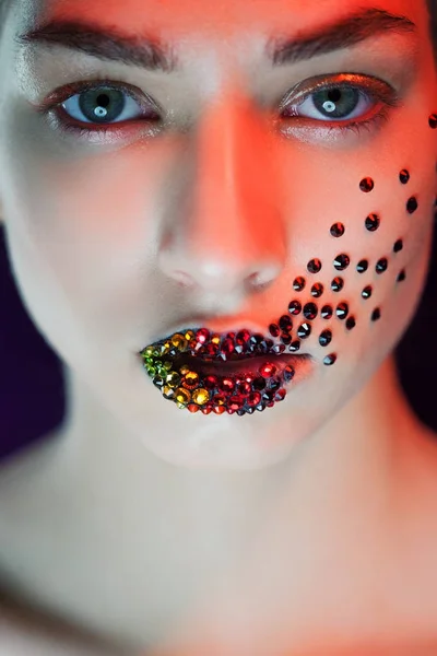 Mavi gözlü genç güzel kız. Parlak makyaj, kırmızı ruj. Sanat, içinde yapay elmas yüz ve dudak — Stok fotoğraf