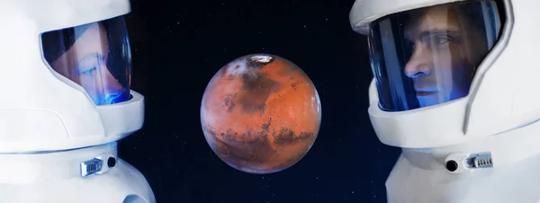Развитие Марса, концепция. Два астронавта, мужчина и женщина смотрят на планету Марс . — стоковое фото