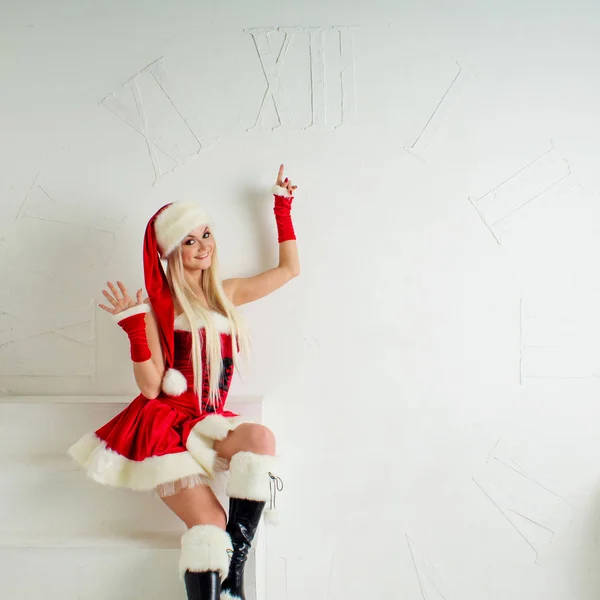 Zabawna dziewczyna w stroju na Boże Narodzenie punktów do oglądania. Santa czerwony kombinezon z kapturem. — Zdjęcie stockowe