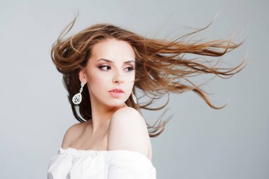 Güzel küpe, portre yakın çekim güzel genç kadın. uçan saç