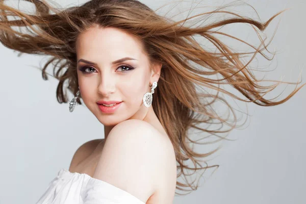 Beautiful young woman with beautiful earrings, portrait close-up. flying hair — Stock Photo, Image