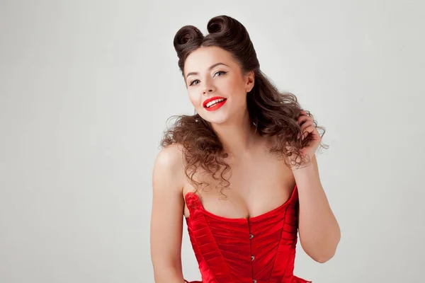 Charming lady in red corset, pin-up hairstyle — Stock Photo, Image