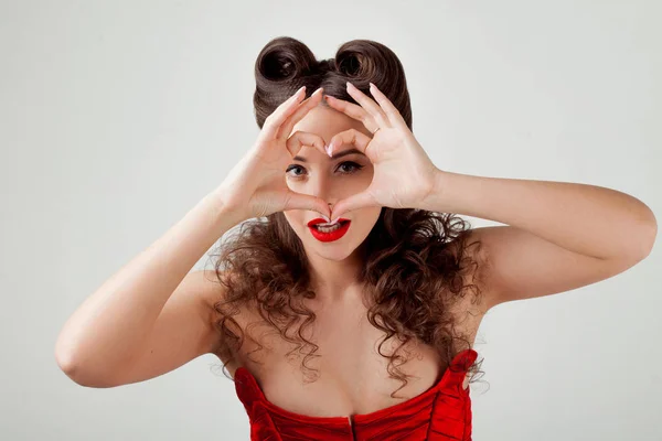 Senhora encantadora em espartilho vermelho, mostra sinal de coração — Fotografia de Stock