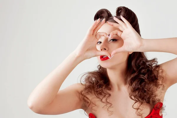 Affascinante signora in corsetto rosso, mostra il cuore segno — Foto Stock