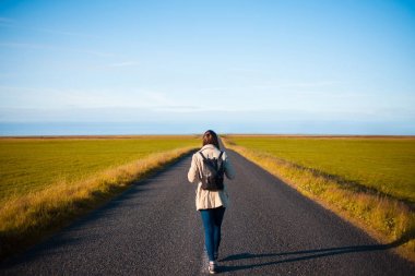 Kadın turist arka plan yolda sırt çantası ile. Hedefe doğru