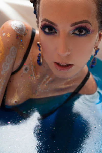 Fiatal gyönyörű nő, ragyogó smink vízben — Stock Fotó