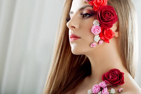 Hermosa joven con flores apliques en la cara . — Foto de Stock