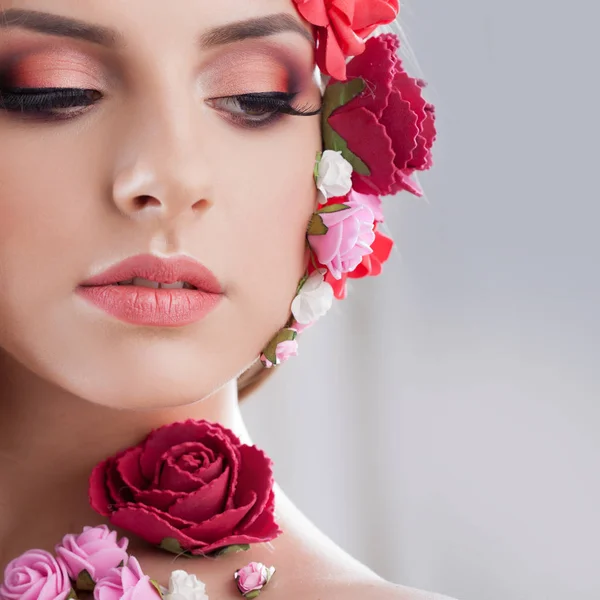 Mooi jong meisje met stoffen bloemen op het gezicht. — Stockfoto