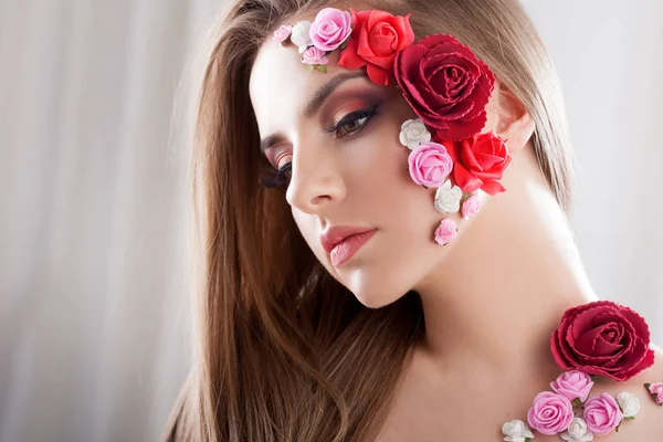 Hermosa joven con flores apliques en la cara . — Foto de Stock