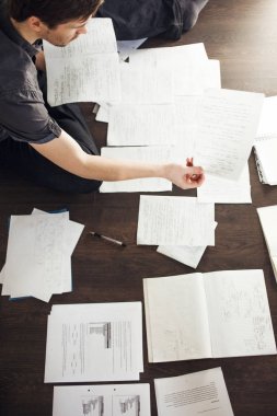 Genç erkek girişimci kattaki dairede oturan beyin fırtınası yapar. İş için yaratıcı yaklaşım