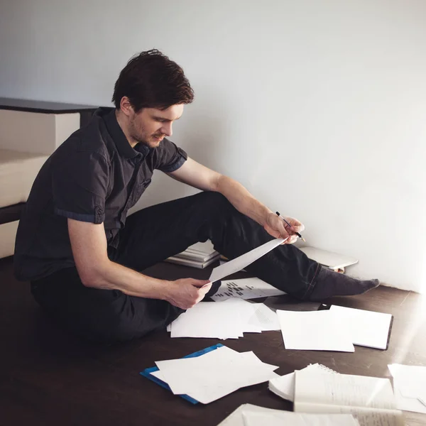 Mladý muž podnikatel dělá, brainstorming, sedí na podlaze v bytě. Kreativní přístup k podnikání — Stock fotografie