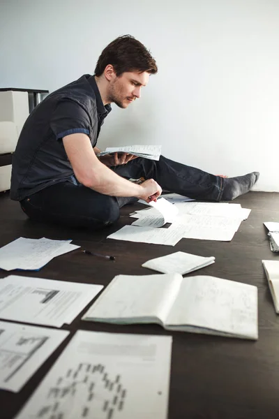 Young male entrepreneur makes brainstorming sitting on the floor in the apartment. Creative approach to business — Stock Photo, Image