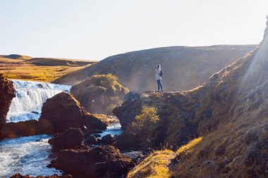 Bir dağ nehir arka plan üzerinde kadın turist