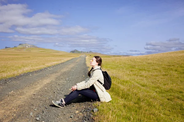Jovem turista senta-se na estrada . — Fotografia de Stock