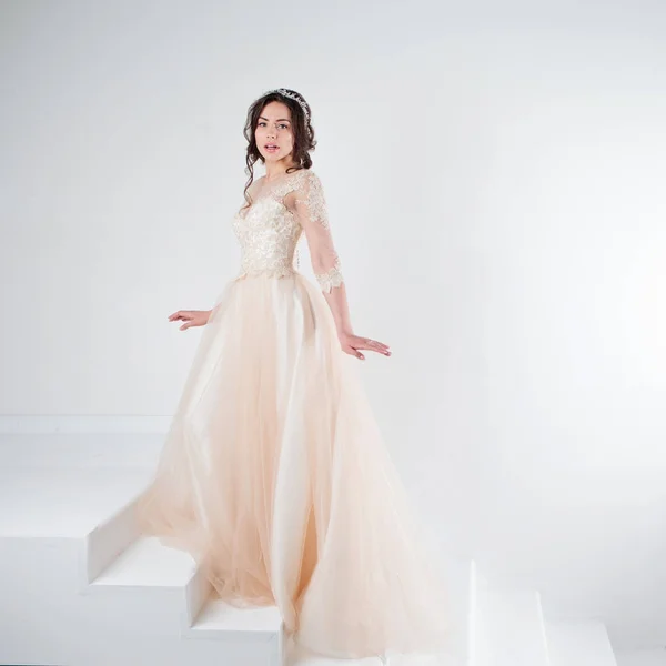 Retrato de uma menina bonita em um vestido de noiva. Noiva em um vestido de luxo em pé nas escadas, subir — Fotografia de Stock