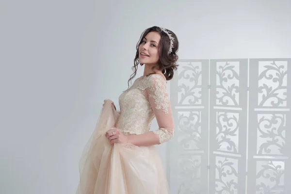 Retrato de una hermosa chica en un vestido de novia. Novia en un vestido de lujo, en un hermoso interior blanco — Foto de Stock