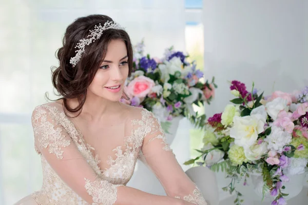 Retrato de una hermosa chica en un lujoso vestido de novia. Interior decorado con flores — Foto de Stock