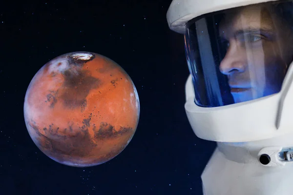 Разработка Марса, концепция. Астронавт смотрит на планету Марс. Элементы этого изображения предоставлены НАСА . — стоковое фото