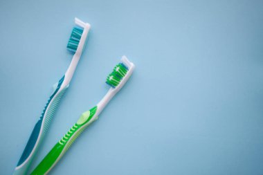 Mavi arka plan üzerinde iki diş fırçaları