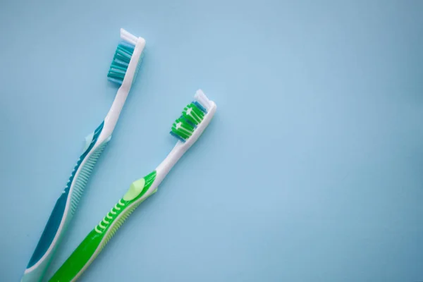Duas escovas de dentes no fundo azul — Fotografia de Stock