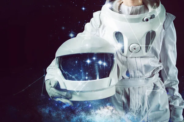 Astronaut v skafandr drží helmu v ruce. Detail, kombinovaná technika — Stock fotografie