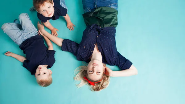 Mãe e filhos, retrato sobre fundo azul — Fotografia de Stock