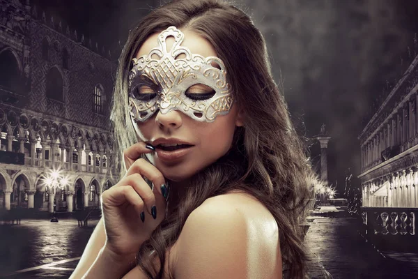 Beautiful brunette with Venetian mask. Young and beautiful woman on Venetian view background. — Stock Photo, Image