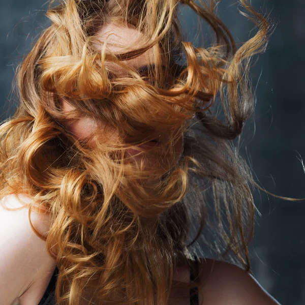 Ottimi capelli ricci. Felice bella ragazza rossa. Studio ritratto su sfondo strutturato. Capelli lunghi volanti — Foto Stock